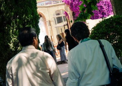 DNSG 2026 participants walking through the shaded gardens towards the symposium venue.