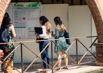 Attendees viewing scientific posters displayed beside the pool during the DNSG 2026 symposium.