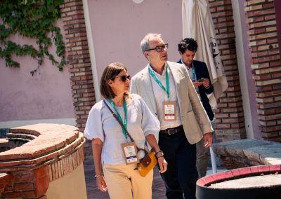 Two DNSG 2026 attendees walking through the historic outdoor areas of the symposium venue.