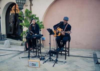 Two musicians performing with vocals, keyboard and acoustic guitar during the DNSG 2026 reception.