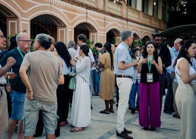 DNSG 2026 participants talking in groups and sharing refreshments during the courtyard reception.