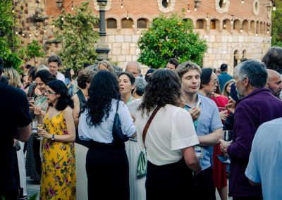 Attendees networking and sharing refreshments in the courtyard during the DNSG 2026 symposium.