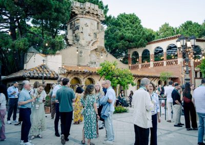 Wide view of DNSG 2026 attendees socialising beneath string lights in a historic courtyard.