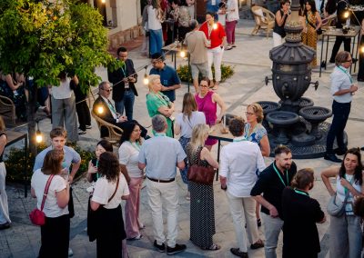 Overhead view of participants talking in groups during an evening networking event at DNSG 2026.