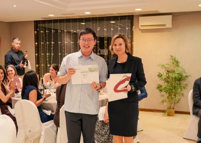 DNSG 2026 participant displaying an award certificate beside the presenter during the ceremony.